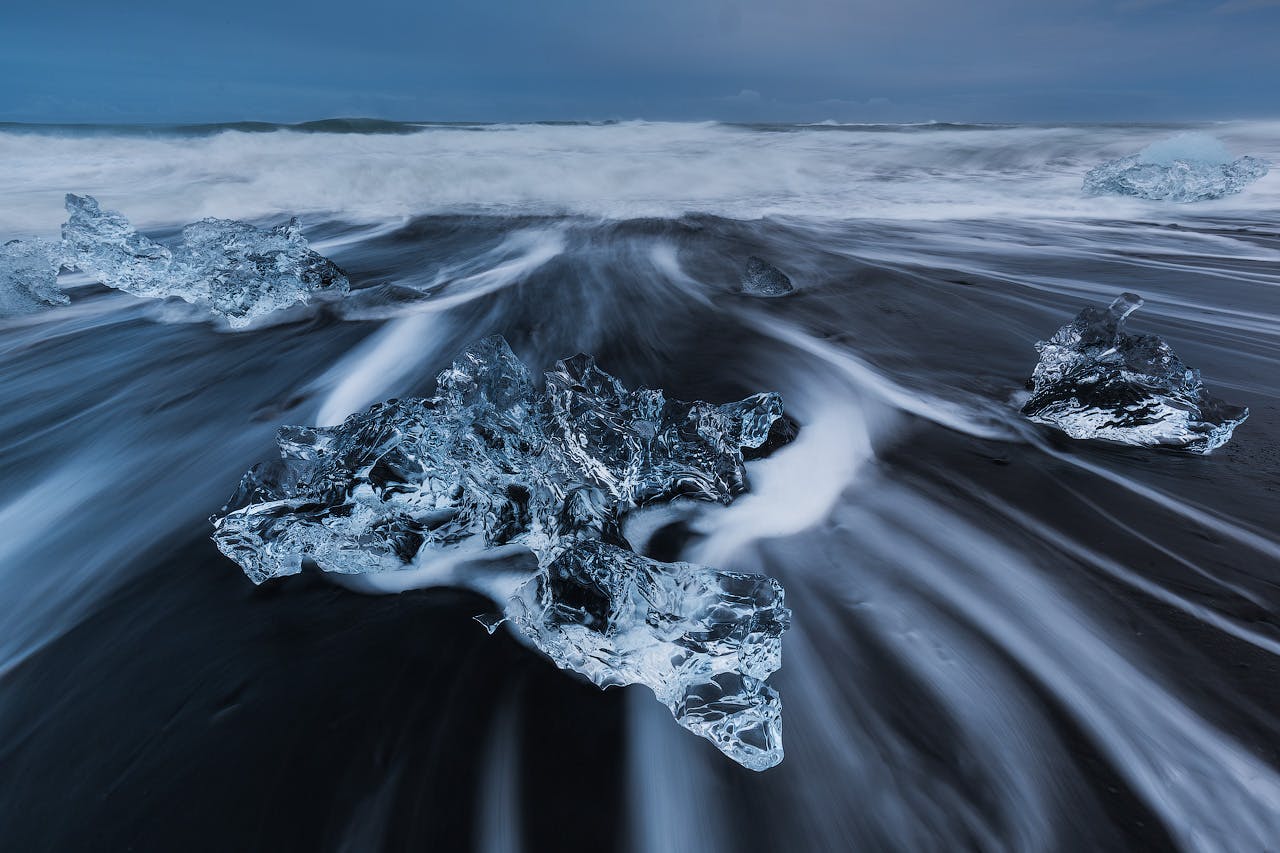 ก้อนน้ำแข็งที่ใสอย่างน่าเหลือเชื่อไหลเอื่อยๆไปยังไดมอนด์บีชในชายฝั่งทางใต้ของประเทศไอซ์แลนด์.