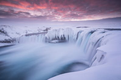 Goðafoss waterfall resembles an icy gnarled monster in the depths of winter as it freezes in places.