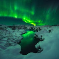 The Northern Lights swirling around in the sky above Þingvellir National Park.