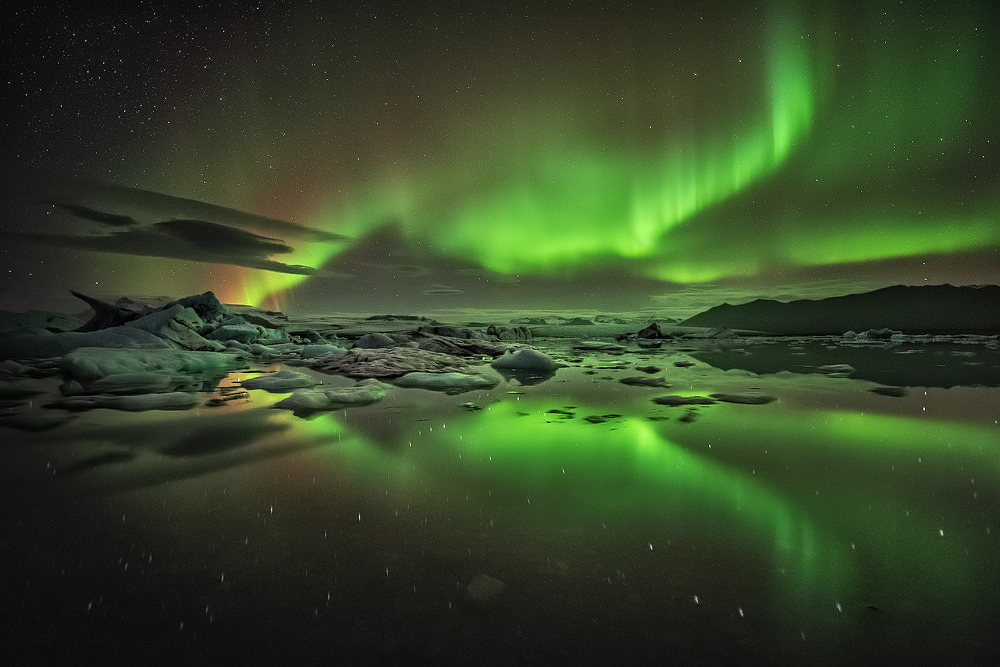 แสงเหนือสีเขียวปรากฏขึ้นบนท้องฟ้าเหนือทะเลสาบธารน้ำแข็งโจกุลซาลอน.