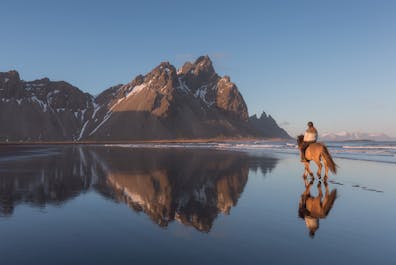 A horse ride galloping on the Stokknes Peninsula, just in front of Vestrahorn Mountain.