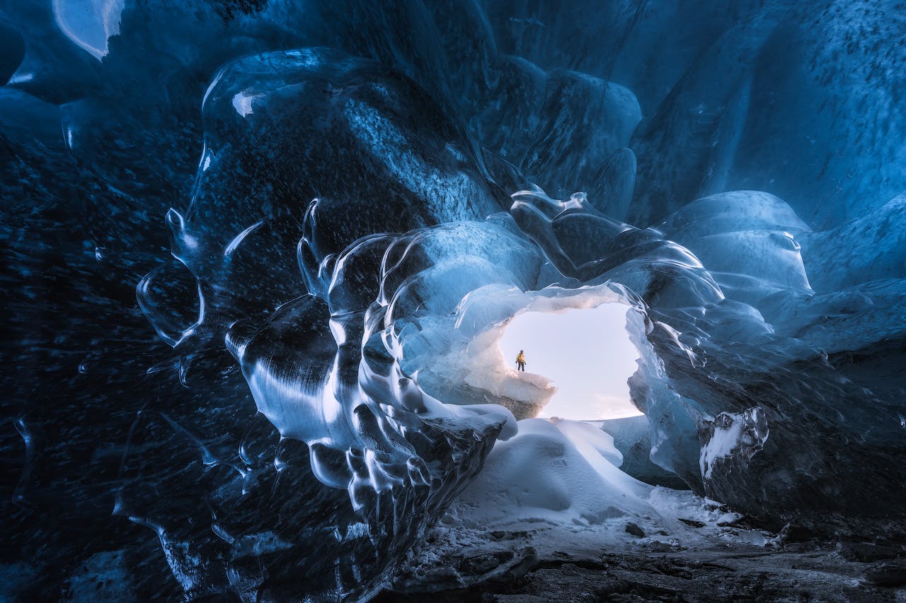 Entra in una grotta di ghiaccio e resta a bocca aperta per il blu brillante del ghiaccio.