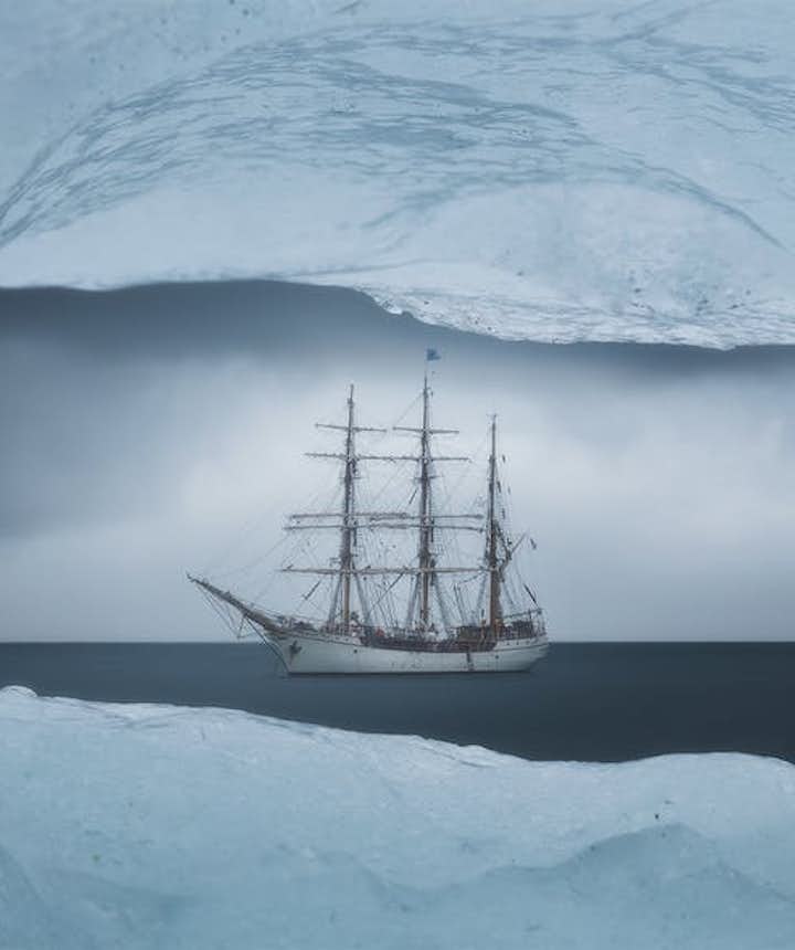A boat is framed by a window of ice - landscape Photography | Everything You Need To Know