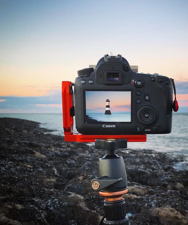 A digital camera sits on a tripod in a coastal scene - types of cameras | digital