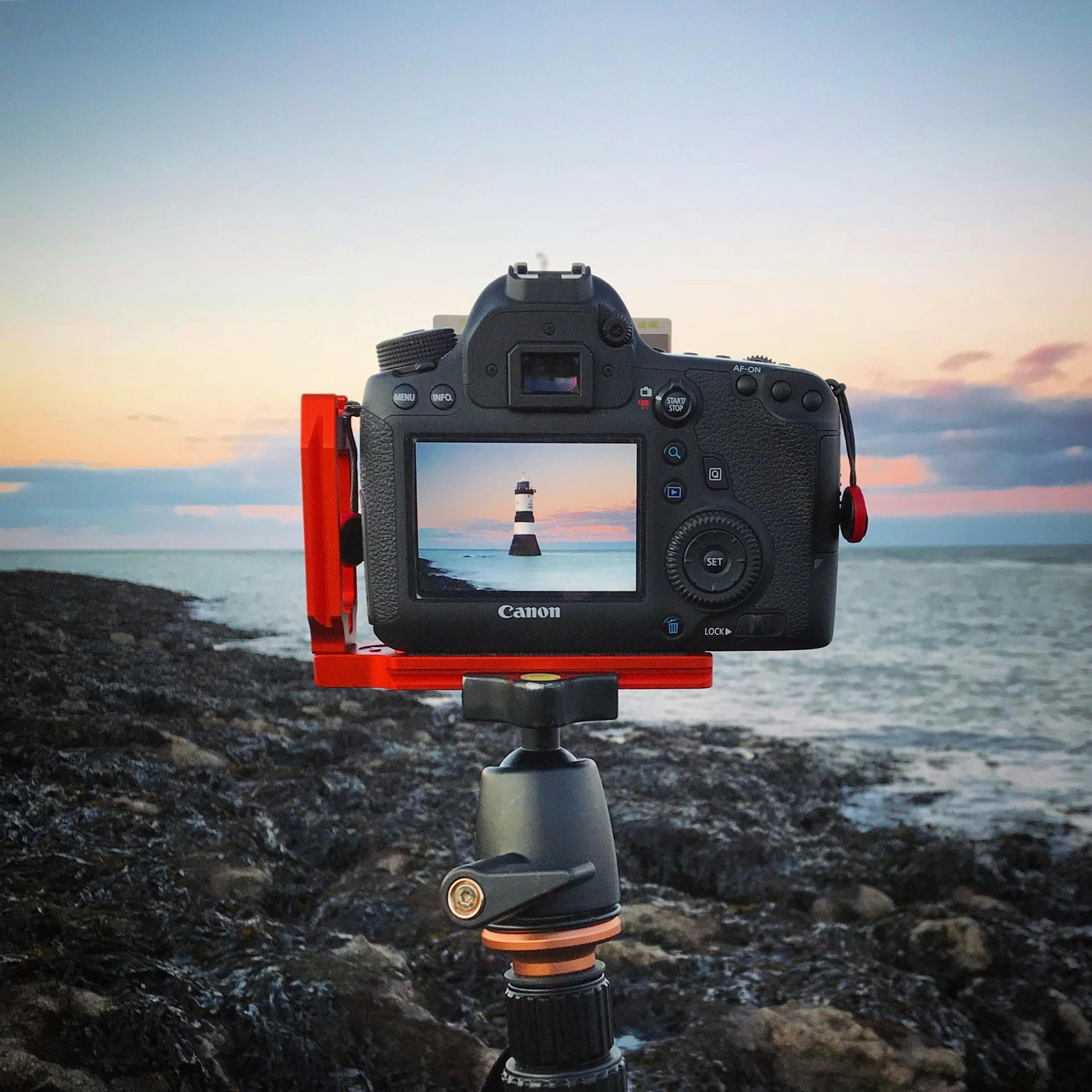 een digitale camera zit op een statief in een kustscene - soorten camera' s | digitale