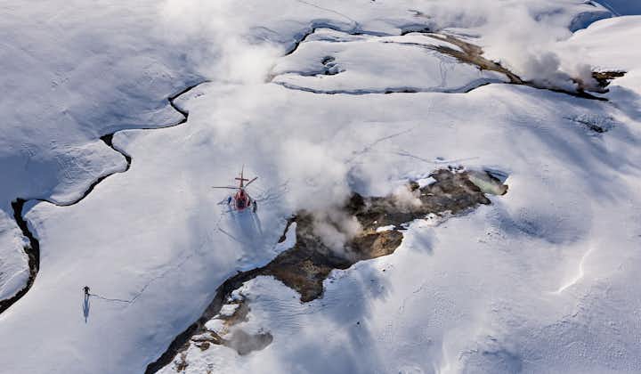 Witness the elegant descent as the helicopter lands softly on the untouched expanse of snow, promising a unique geothermal adventure.