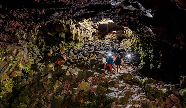 People with flashlights in the Raufarholshellir lava cave near Reykjavik.