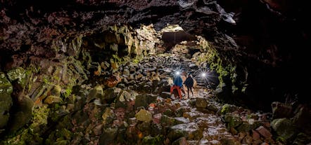 People with flashlights in the Raufarholshellir lava cave near Reykjavik.