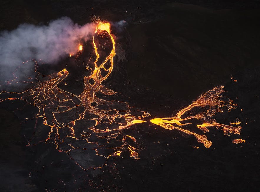 The lava of Geldingadalur glows on the dark, winter night in Iceland.