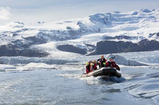 A zodiac boat sailing through the icy waters of the Fjallsarlon lagoon in Iceland.