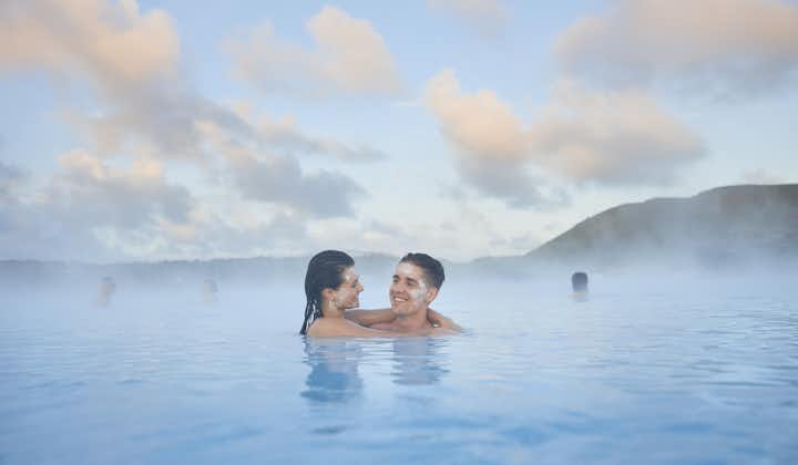 A couple with silica mud masks on their faces, relax in the milky-blue waters of the Blue Lagoon geothermal spa.