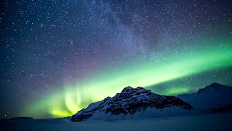 Dancing curtains of vibrant Northern Lights illuminate the night sky in a mesmerizing celestial display.