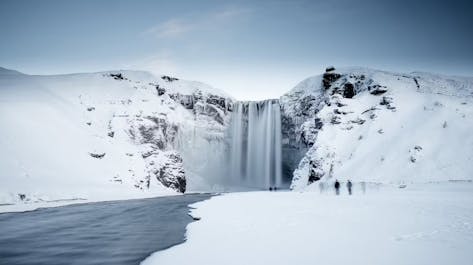 Winter's icy grip transforms Skogafoss into a frozen wonderland, as its cascading waters become adorned with delicate icicles.