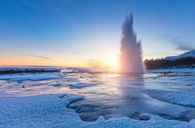 Strokkur geyser defies the cold, erupting in a spectacular display of steam and ice, a natural wonder of Iceland's icy season.