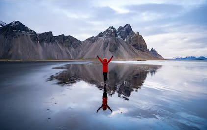 Vestrahorn's majestic peaks mirror their splendor in the tranquil waters, creating a symphony of mountains and reflections.