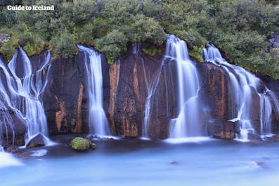 Crystal-clear waters cascade through the rugged lava fields, creating the enchanting beauty of Hraunsfossar waterfall.