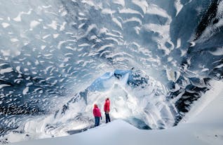 People look up at the mesmerizing ice formations in the Askur ice cave on the Myrdalsjokull glacier.